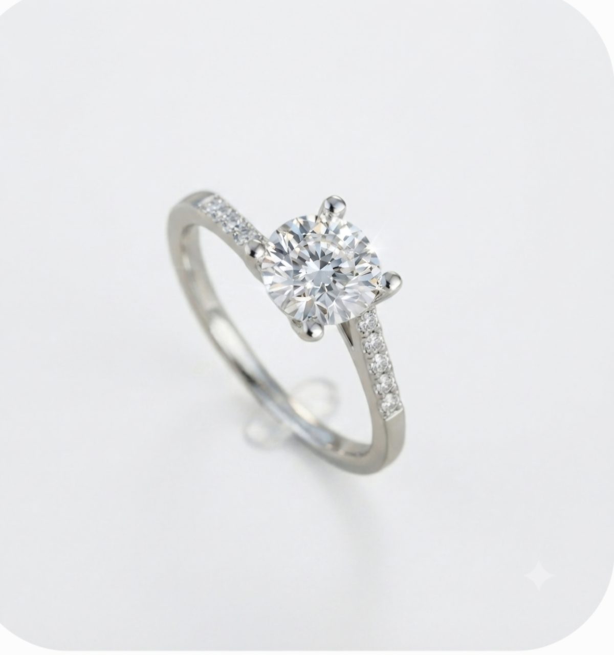 AmandaScreenshot_20260825_161437_Google(1) Elegant 9ct white gold engagement ring featuring a brilliant round cubic zirconia center stone in a four-claw setting, complemented by pave-set cubic zirconia accent stones along the delicate band.