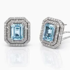 Exquisite 18ct white gold earrings featuring emerald‑cut aquamarine gemstones surrounded by double halos of sparkling round brilliant‑cut diamonds, featuring stud clips for safe wearing.