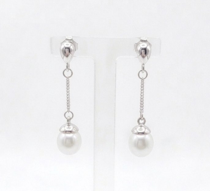1775469528056 A pair of sterling silver drop Freshwater Pearl earrings featuring small, polished teardrop-shaped studs at the top. A delicate silver chain hangs from each stud, ending in a round white pearl topped with a small silver cap. With push on butterflies.
