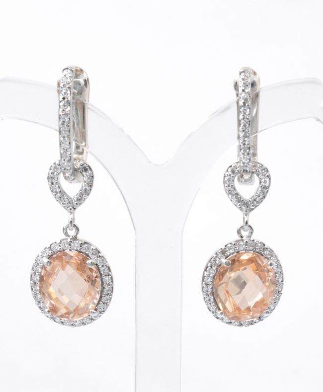 Elegant sterling silver pretty woman earrings featuring pave-set stud clip and pear-shaped links, finished with oval peach-toned cubic zirconia stones surrounded by sparkling white cubic zirconia halos.