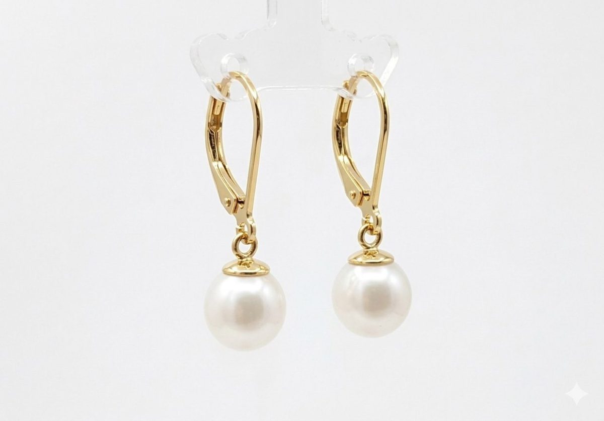 A pair of elegant drop earrings featuring drop, creamy white freshwater pearls suspended from delicate gold plated French hooks.