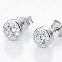 A pair of classic round-cut stud earrings set in polished 9ct White gold bezel, with push on butterflies.