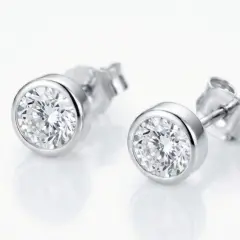 A pair of classic round-cut stud earrings set in polished 9ct White gold bezel, with push on butterflies.