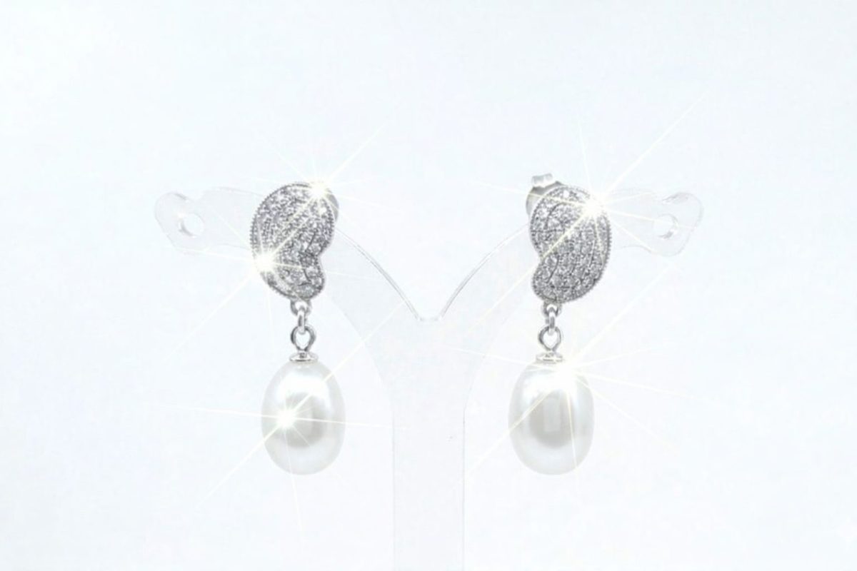 A pair of silver-toned drop earrings featuring a textured, leaf-shaped top encrusted with sparkling Cubic Zirconia's. Each earring is finished with an oval white Freshwater pearl that catches a bright, brilliant sparkle. With push on butterflies.