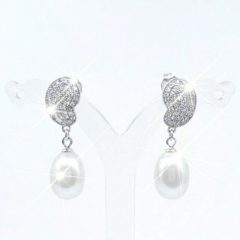 A pair of silver-toned drop earrings featuring a textured, leaf-shaped top encrusted with sparkling Cubic Zirconia's. Each earring is finished with an oval white Freshwater pearl that catches a bright, brilliant sparkle. With push on butterflies.