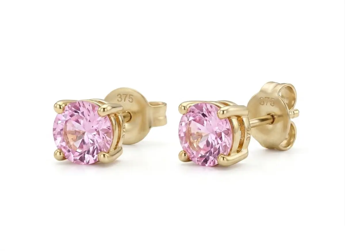 1777365123799 Pair of round-cut soft pink sapphire stud earrings set in 9ct. Yellow gold four-claw mountings.