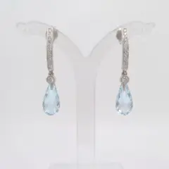 A pair of 9ct White Gold earrings featuring a row of small diamonds on an arched bar, with a bezel-set diamond und a faceted blue topaz briolette teardrop pendant hanging from each.