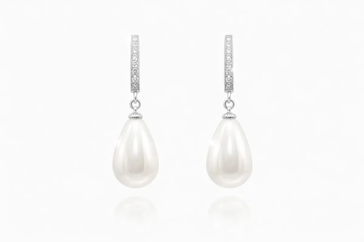 Pair of sterling silver drop earrings featuring lustrous white teardrop shell pearls suspended from cubic zirconia‑encrusted silver bails.