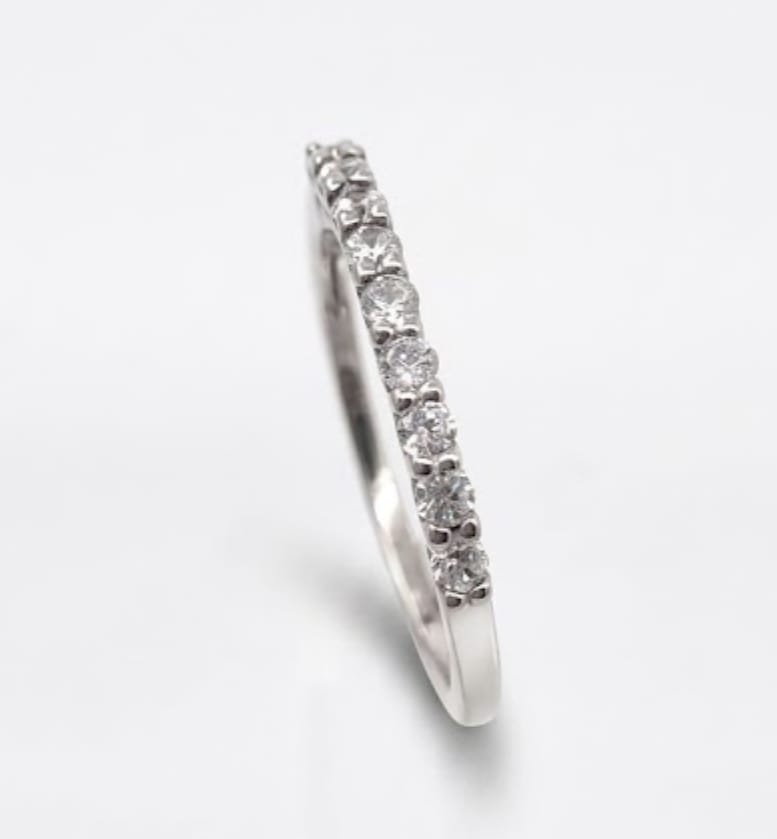 Fine silver ring featuring a row of prong-set round brilliant cubic zirconia stones extending across the front of the band.