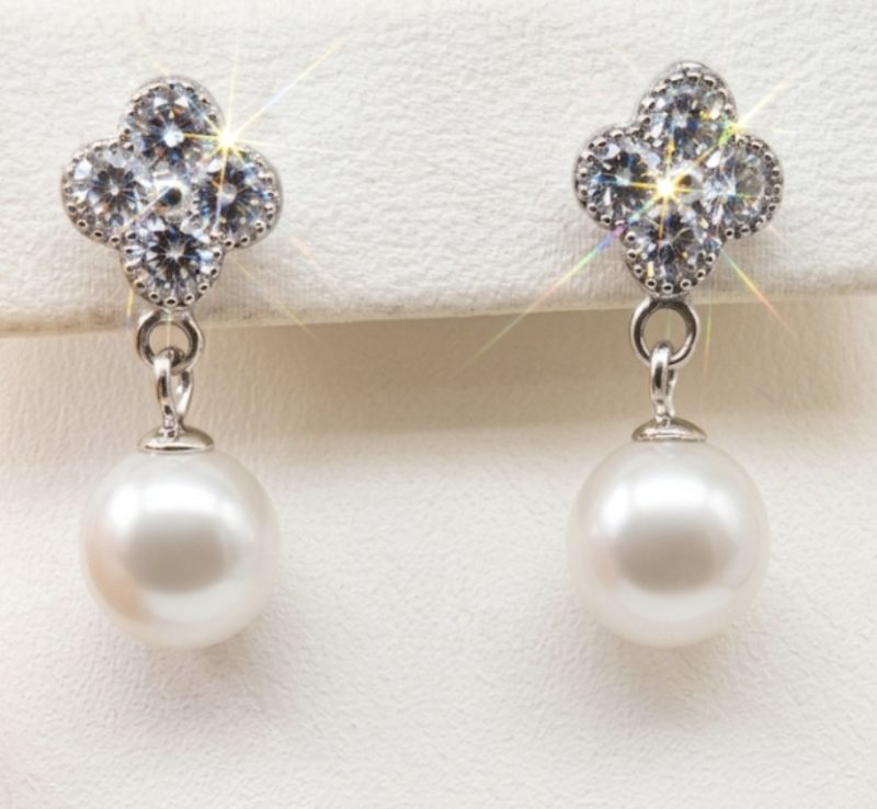 Screenshot_20260405_093830_Google Elegant silver dangling earrings with radiant, shimmering CZ clover tops and round white freshwater pearls, with push on butterflies.