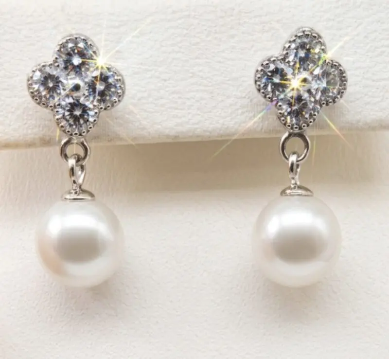 Elegant silver dangling earrings with radiant, shimmering CZ clover tops and round white freshwater pearls, with push on butterflies.