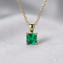 Vibrant green square princess-cut emerald pendant featuring a polished yellow gold bail and four-prong mounting, displayed on a fine gold chain in 9ct.
