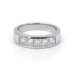 Platinum channel‑set ring featuring five princess‑cut diamonds arranged in a seamless row, photographed against a pure white background. The polished platinum band reflects soft light, while each diamond catches a crisp sparkle, showcasing precision craftsmanship and modern elegance.