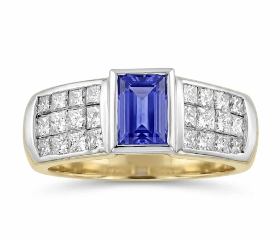 Agate20260905_175958_Gallery 18ct. yellow gold ring with a bezel-set rectangular tanzanite center stone flanked by channel-set princess-cut diamonds. Top of ring is white gold rhodium plated.