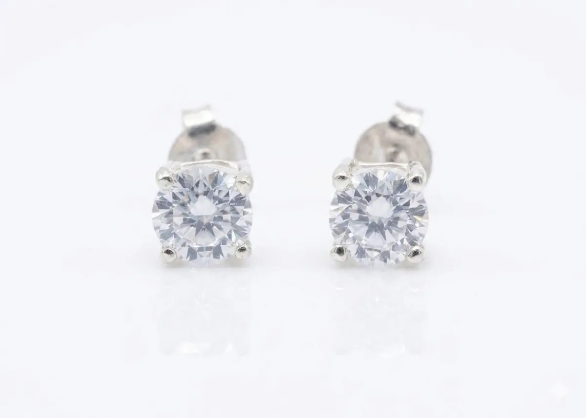 Friesa A pair of round-cut cubic zirconia stud earrings set in sterling silver, with push on butterflies.