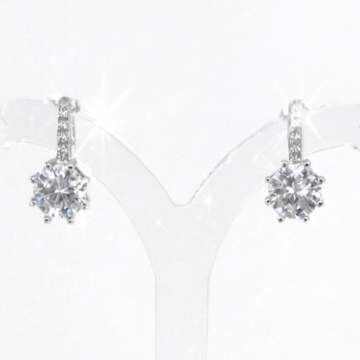 Brilliant silver cubic zirconia stud earrings. Each earring features a round brilliant cut CZ stone set in a polished 6 prong silver mount, with small cz on the bar above, stud clip finish.