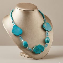 A beautiful Howlite turquoise colour and crystal beaded necklace. It features large, irregularly shaped tuquoise stones accented by smaller, faceted clear crystals an turquoise colour Howlit beads.