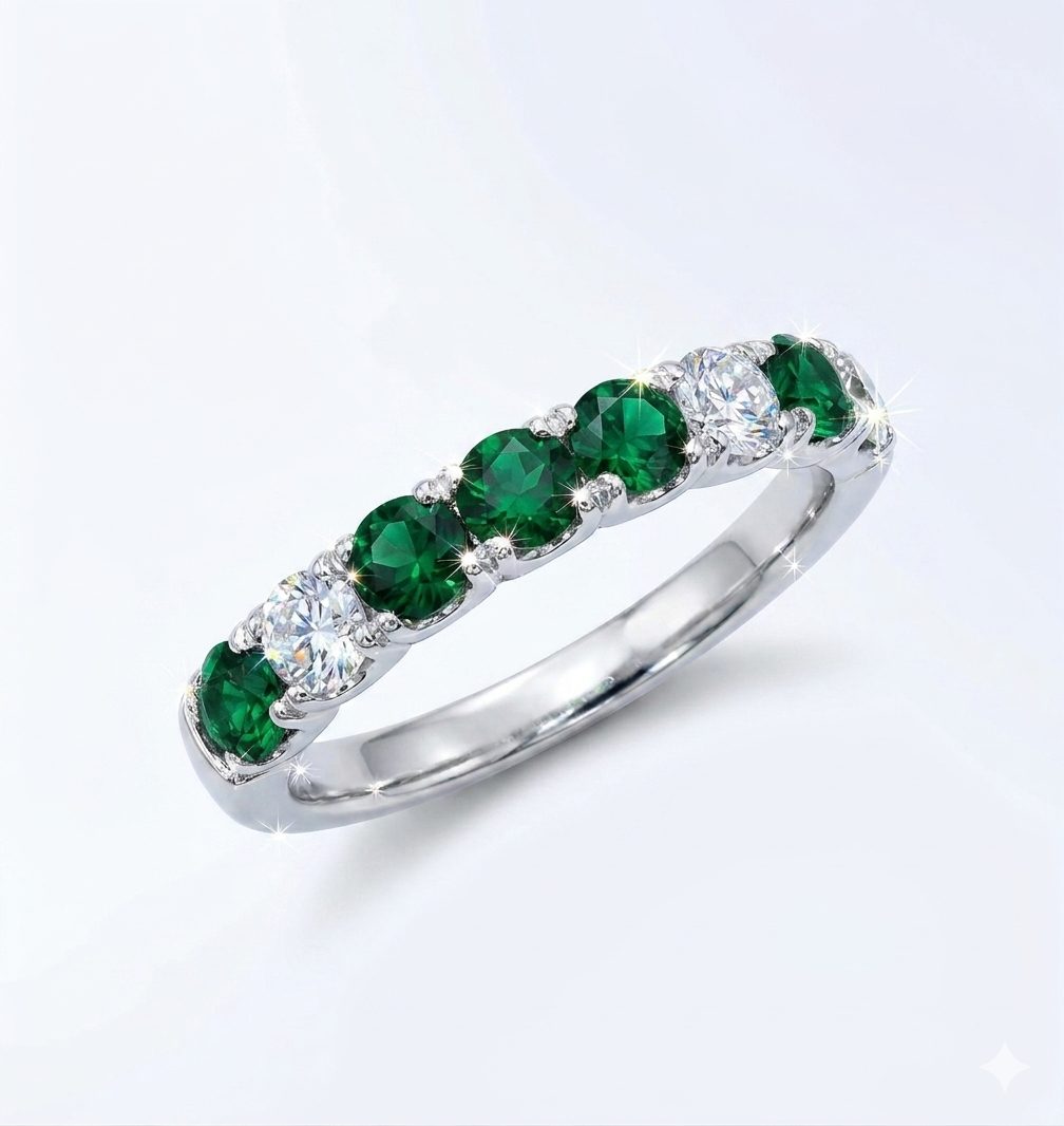 1777723043402 A detailed product of a white gold eternity band set with round green Tourmalines and wound diamonds. The stones are arranged in an alternating pattern with larger 3 Tourmalines in the center.