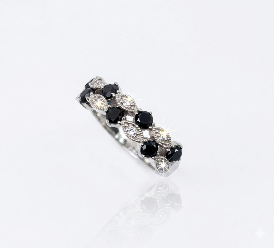 A 9ct. White Gold ring featuring a distinctive marquise and round-cut pattern. The band showcases alternation section: marquise-shaped settings pave-set with small brilliant white diamonds what emit bright, star-shaped sparkles, and round black diamonds secured by delicate prongs (claws).