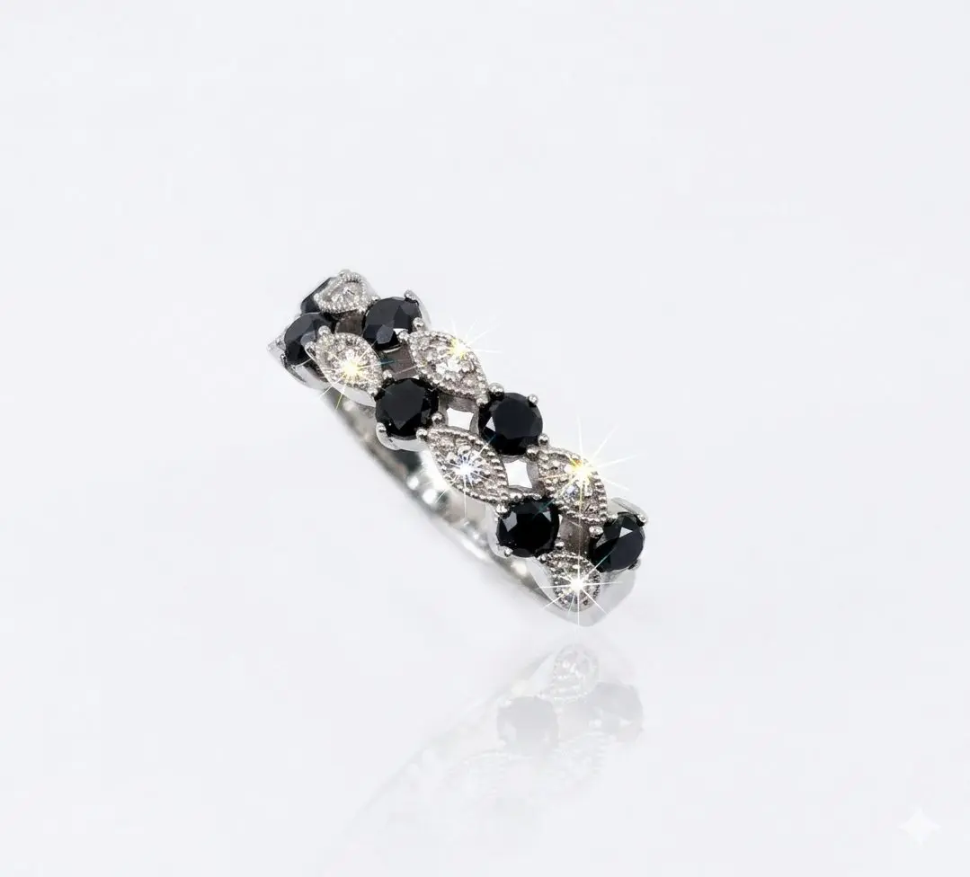A 9ct. White Gold ring featuring a distinctive marquise and round-cut pattern. The band showcases alternation section: marquise-shaped settings pave-set with small brilliant white diamonds what emit bright, star-shaped sparkles, and round black diamonds secured by delicate prongs (claws).