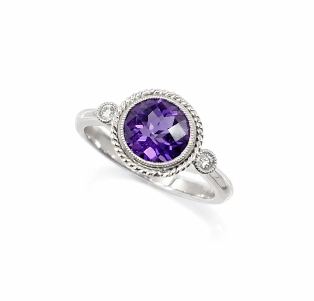 Elegant 14ct white gold ring featuring a round 6.5 mm amethyst framed by a twisted rope halo and accented with two brilliant-cut diamonds.