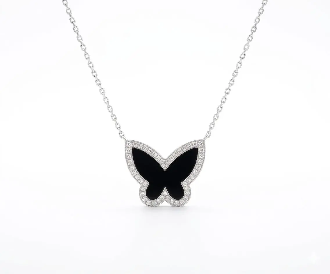 A high-quality 18ct. White gold butterfly pendant necklace featuring a striking black onyx inlay wing design. The butterfly is bordered by a delicate row of shimmering pave-set diamonds an suspended from a polished 18ct. White Gold Anchor chain.