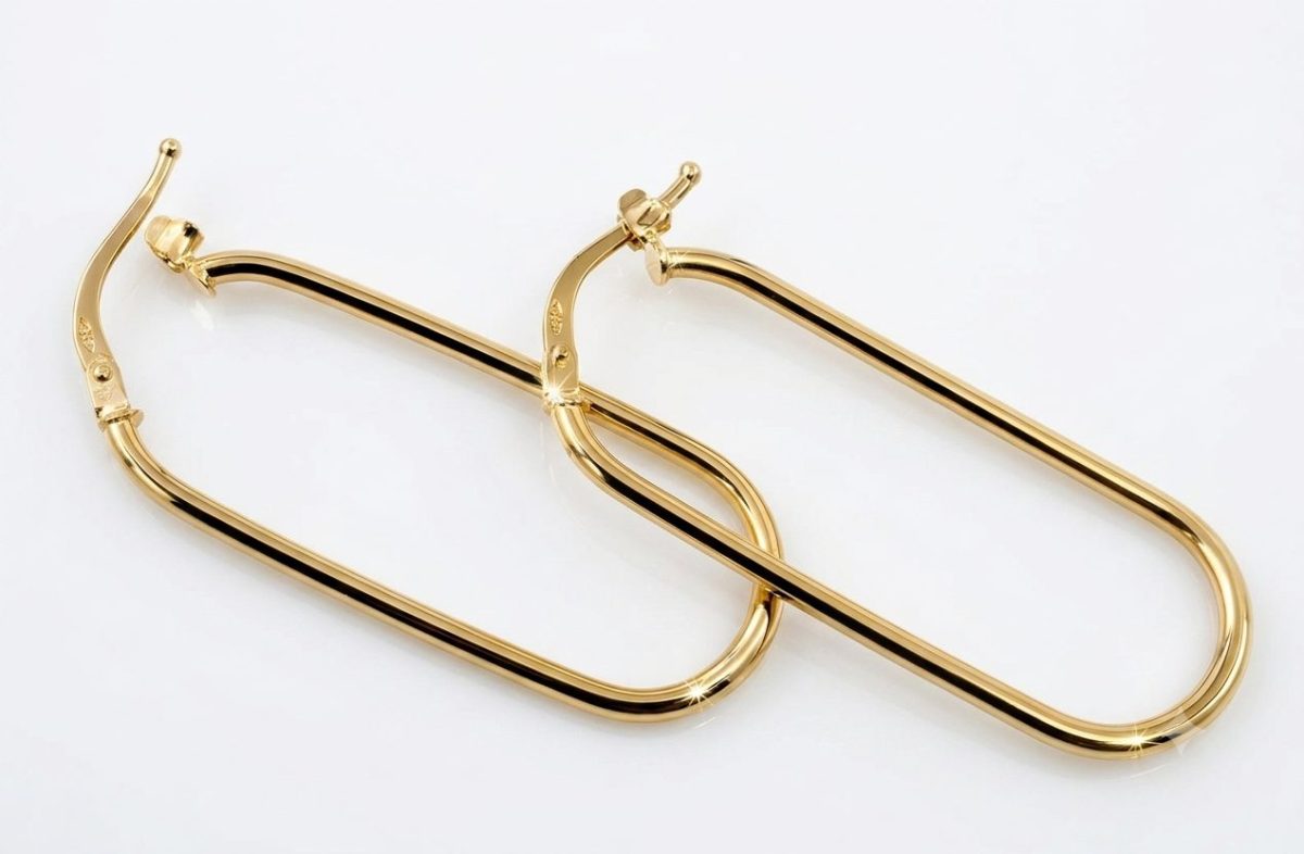 A pair of polished 9ct yellow gold hoop earrings with an elongated, rounded rectangular shape arranged diagonally. Featuring highlighted reflections to emphasize the metallic shine.