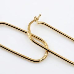 A pair of polished 9ct yellow gold hoop earrings with an elongated, rounded rectangular shape arranged diagonally. Featuring highlighted reflections to emphasize the metallic shine.