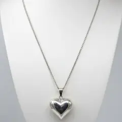 Sterling silver puffed heart pendant on a white Jewellery mannequin.
