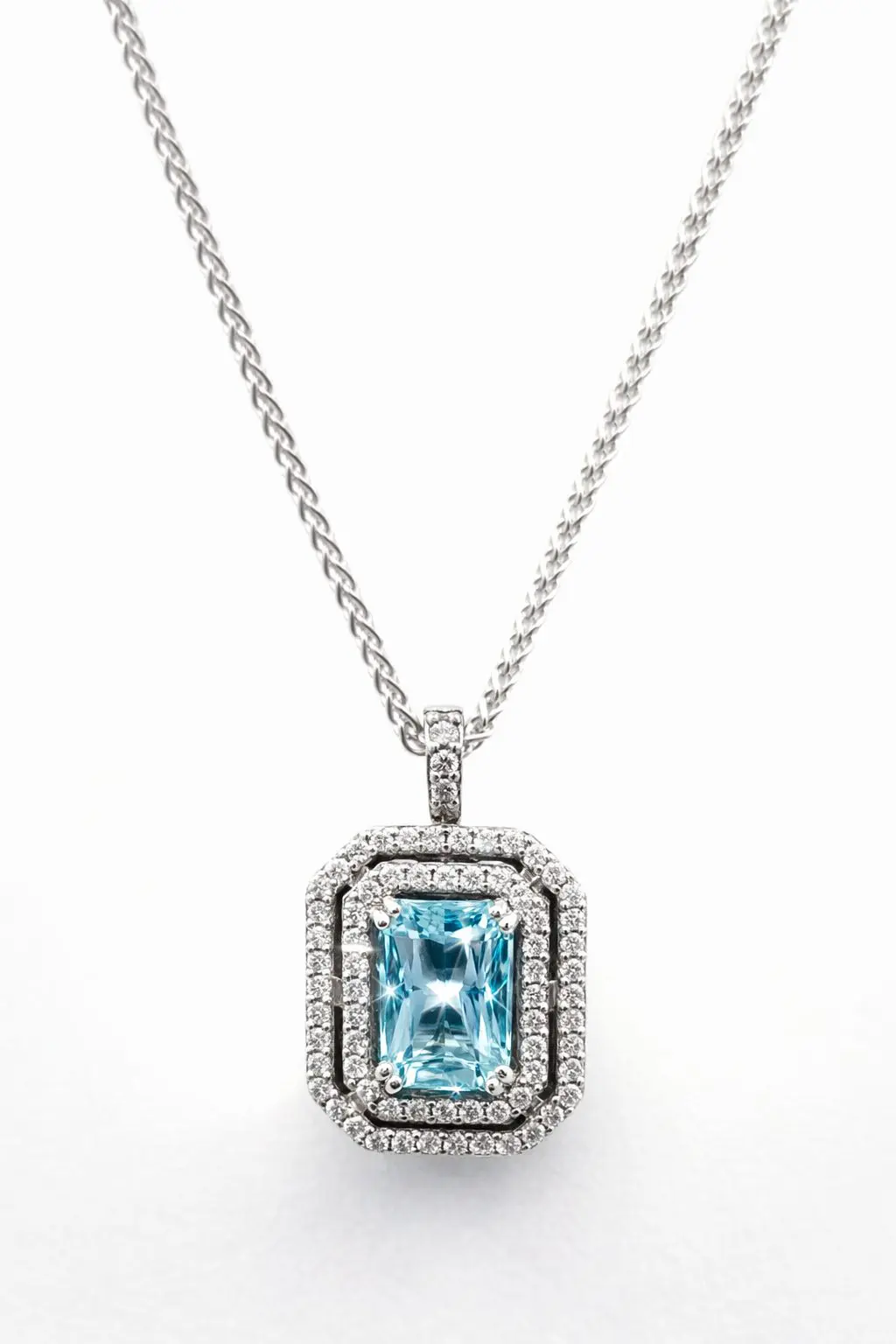 White gold pendant with aquarmine and diamond halo on white gold wheat chain.