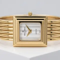 A vintage Michel Herbelin Corynthe ladies' watch featuring a rectangulare gold-plated case and a unique five-strand gold bangle bracelet. The timepiece has a minimalist white vertical-striped dial with gold dauphine hands, presented as a high-quality preloved luxury accessory.