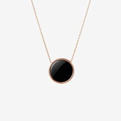Featuring a polished circular black onyx gemstone set in a rose gold bezel frame, suspended from a matching delicate rose gold chain.
