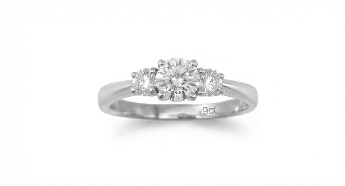 A timeless three-stone setting featuring a striking center lab grown diamond of 0.50ct flanked by two matching side lab grown diamonds of 0.20ct. set in 9ct. White Gold, size M