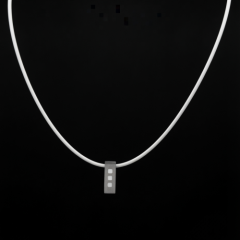 Stainless steel pendant featuring three white enamel square inlays, suspended on a smooth white rubber cord with a secure clasp. 50 cm long