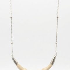 Designer silver necklace featuring a curved, segment-carved bone center piece suspended from a delicate chain with small bead accents.