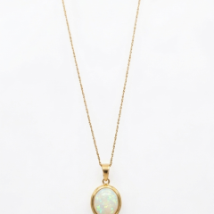 18ct yellow-gold oval opal pendant on a delicate 9ct yellow-gold chain, featuring a bezel-set opal with iridescent pastel flashes.